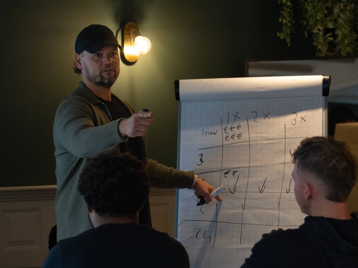 Mitch bespreekt een schema op de flipchart met de groep